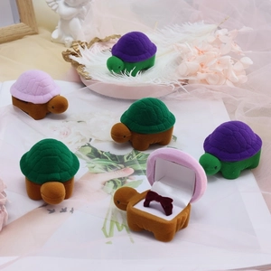Close-up of velvet turtle-shaped jewelry boxes with soft satin lining and ring slots