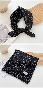 Detail of a floral black cotton neckerchief with white lace trim in a vintage rustic style