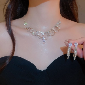 Dettaglio della collana con ciondolo di strass e set di orecchini coordinati