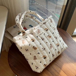 Quilted cotton tote bag with bear and bow patterns on a wooden table setup