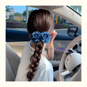 Close-up of dual blue denim flower hair clips styled on a braided hairstyle