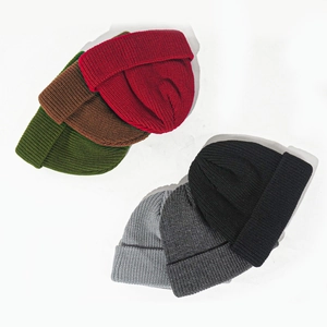 Collection of six colorful warm acrylic knit beanies stacked on a white background