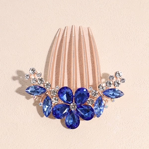 Detailed shot of rose gold hair comb with blue crystal flower and clear rhinestones
