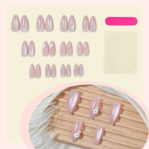 Pink press-on nails set with 3D white flowers, pearls, and French tip cat-eye design