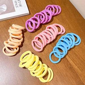 Macaron color elastic seamless hair ties set on a dark wood background for daily styling
