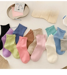 Detailed flat lay of ten colorful rolled-cuff cotton socks in diverse candy colors