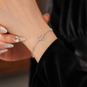 Detail of silver clover bracelet with marquise zircons worn on a female wrist