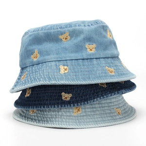 Detail of bear embroidery on washed denim bucket hats in light, mid, and dark blue