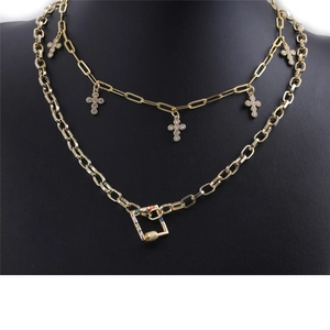 Détail d'un collier double épaisseur doré avec pendentifs croix et boucle en pierre colorée
