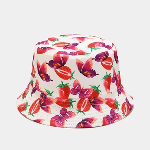 Detailed view of white bucket hat with strawberry and butterfly prints in vibrant colors