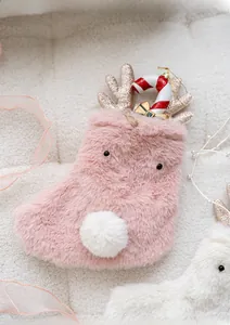 Detailed view of pink plush Christmas stocking with gold antlers and candy cane accents