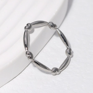 Minimalist silver heart and olive bead stainless steel ring on a white background