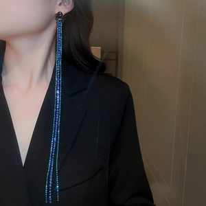 Detailed view of long cascading chain earrings with shimmering blue purple rhinestones