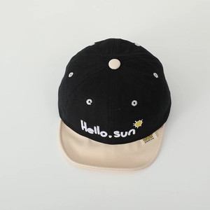 Détail de la casquette coton bébé avec broderie 'Hello. sun' et logo soleil cousu