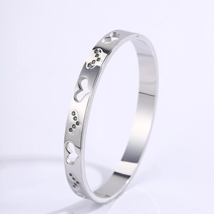 Macro detail of silver titanium steel bangle with heart cutouts and shiny crystals