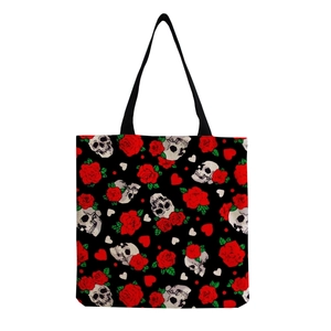 Detail of canvas tote bag featuring skull and red rose prints with sturdy black straps