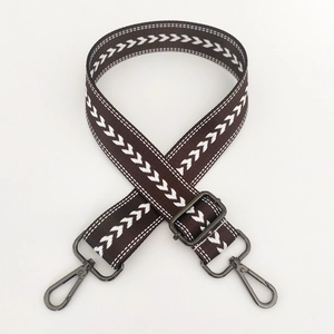 Close-up of brown nylon bag strap with white arrow pattern and dark metal swivel hooks