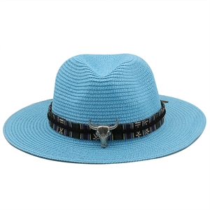 Close-up of sky blue straw hat with ethnic ribbon and vintage silver bull head ornament