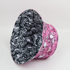 Detail of reversible bucket hat with skull and floral patterns in pink and black