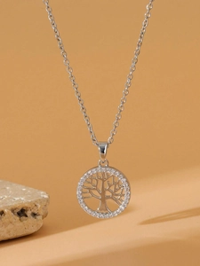 Detail of silver Tree of Life necklace with zircon stones on yellow background