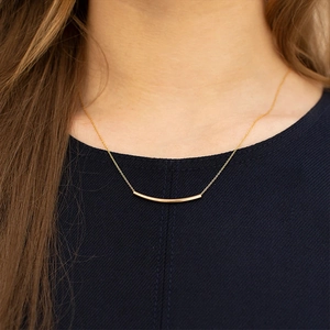 Nahaufnahme einer minimalistischen S925 Silberhalskette mit goldenem gebogenem Stab