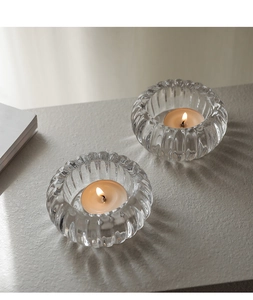 Détails de deux bougeoirs en verre strié avec bougies chauffe-plat sur une surface
