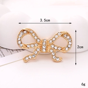 Golden bowknot jewelry accessory with white rhinestones measuring 3.5cm by 2cm for DIY