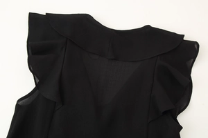 Detail view of the black ruffled chiffon sleeves and sheer layered fabric texture