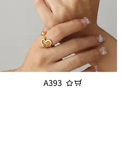 Detail of a wavy gold open ring with small spherical accents worn on a finger