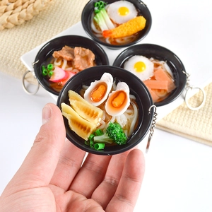 Miniature PVC Japanese udon noodle bowl keychain held in hand showing realistic details