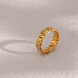 Gros plan sur la bague en acier doré 18K avec motif étoile, zircon et bord tressé