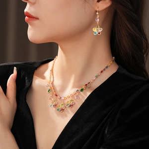 Detail of luxury floral necklace set with colorful zircon and teardrop pendants on model