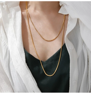 Close-up of double-layered 18K gold-plated square snake chain necklace on white shirt