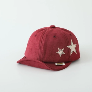 Close-up of baby baseball cap with star patches and textured burgundy velvet fabric
