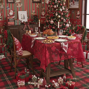 Detail der roten Spitzen-Weihnachtstischdecke mit Weihnachtsmann- und Rentier-Jacquard