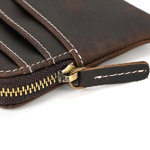 Macro shot of dark brown crazy horse leather wallet with stitching and brass zipper