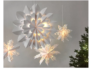 Detail showing hanging white paper star lanterns with warm LED lights for Christmas decor