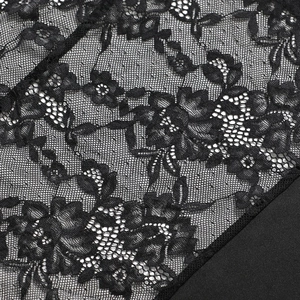 Macro detail of intricate black floral lace pattern on the sexy bodycon dress fabric