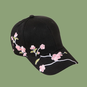 Detailed close-up of pink cherry blossom embroidery on black cotton baseball cap