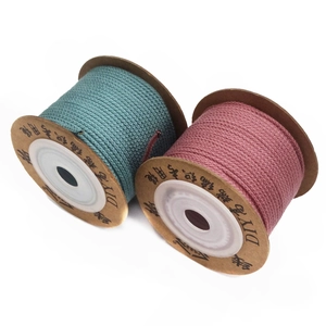Detail of 1.5mm turquoise and dark pink cotton braided cords on white background