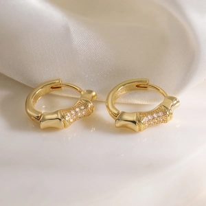18K gold plated bamboo hoop earrings with sparkling cubic zirconia on white marble