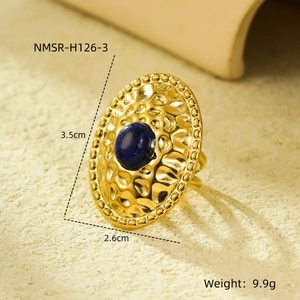 Detailed view of a gold oval ring with blue natural stone and hammered texture measurements
