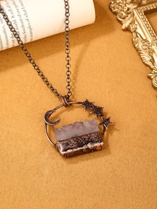 Detail view of vintage bronze moon and stars pendant necklace with raw crystal stone