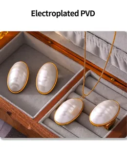 Detail view of oval mother-of-pearl jewelry set in a luxury wooden display case