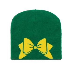 Détail d'un bonnet en tricot vert avec un motif de nœud jaune vif pour l'hiver