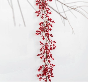 Close-up of artificial red berry garland with dense clusters for holiday home decoration