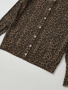 Detailed macro view of animal leopard print knit cardigan with shiny pearl buttons