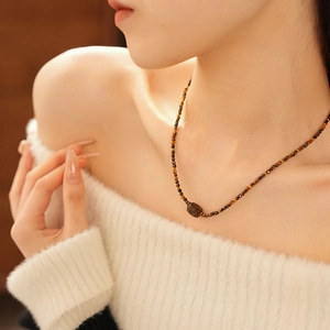 Close-up of tiger eye beaded necklace on model neck showing elegant jewelry design
