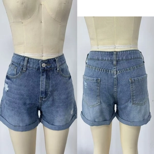Dettaglio fronte e retro degli shorts in denim blu a vita alta con orli risvoltati e usurati