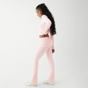 Detailed view of pink ribbed knit texture on two-piece slim fit crop top and flared pants